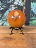 Large orange Polychrome Jasper sphere with yellow orbicular feature, front view