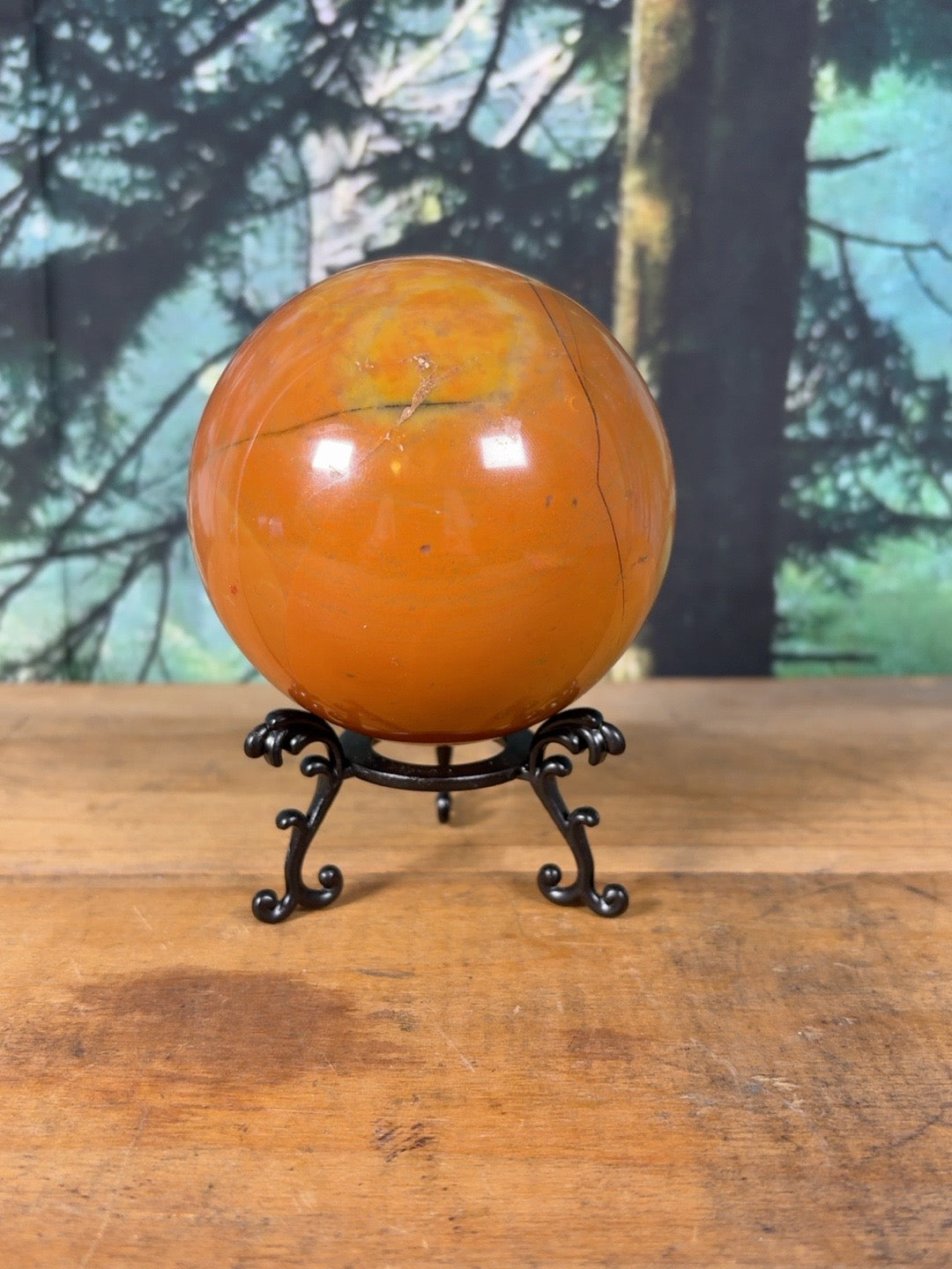 Large orange Polychrome Jasper sphere with natural dark mineral seams