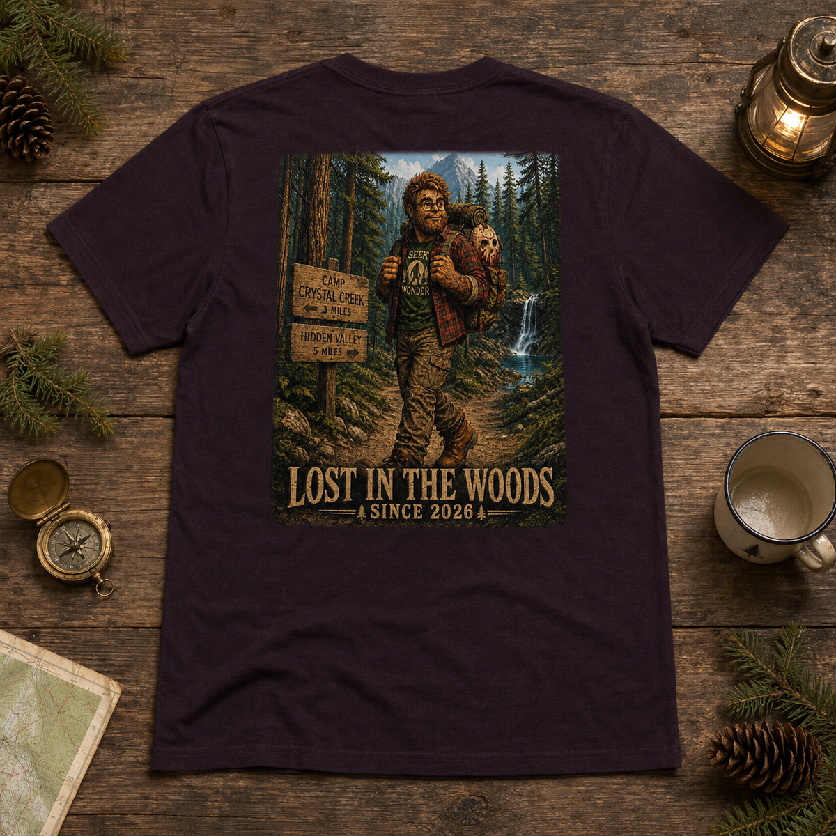 Oxblood Black Henry’s Crystal Lake Camp T-shirt back graphic in a woodland tabletop flat lay