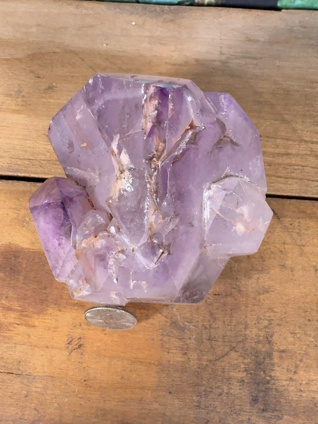Top view of polished amethyst multi-point cluster with quarter for scale