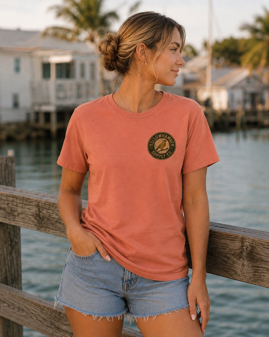 Front view of Yellowhammer Supply Co. Sunset T-shirt with left chest Yellowhammer logo on female model