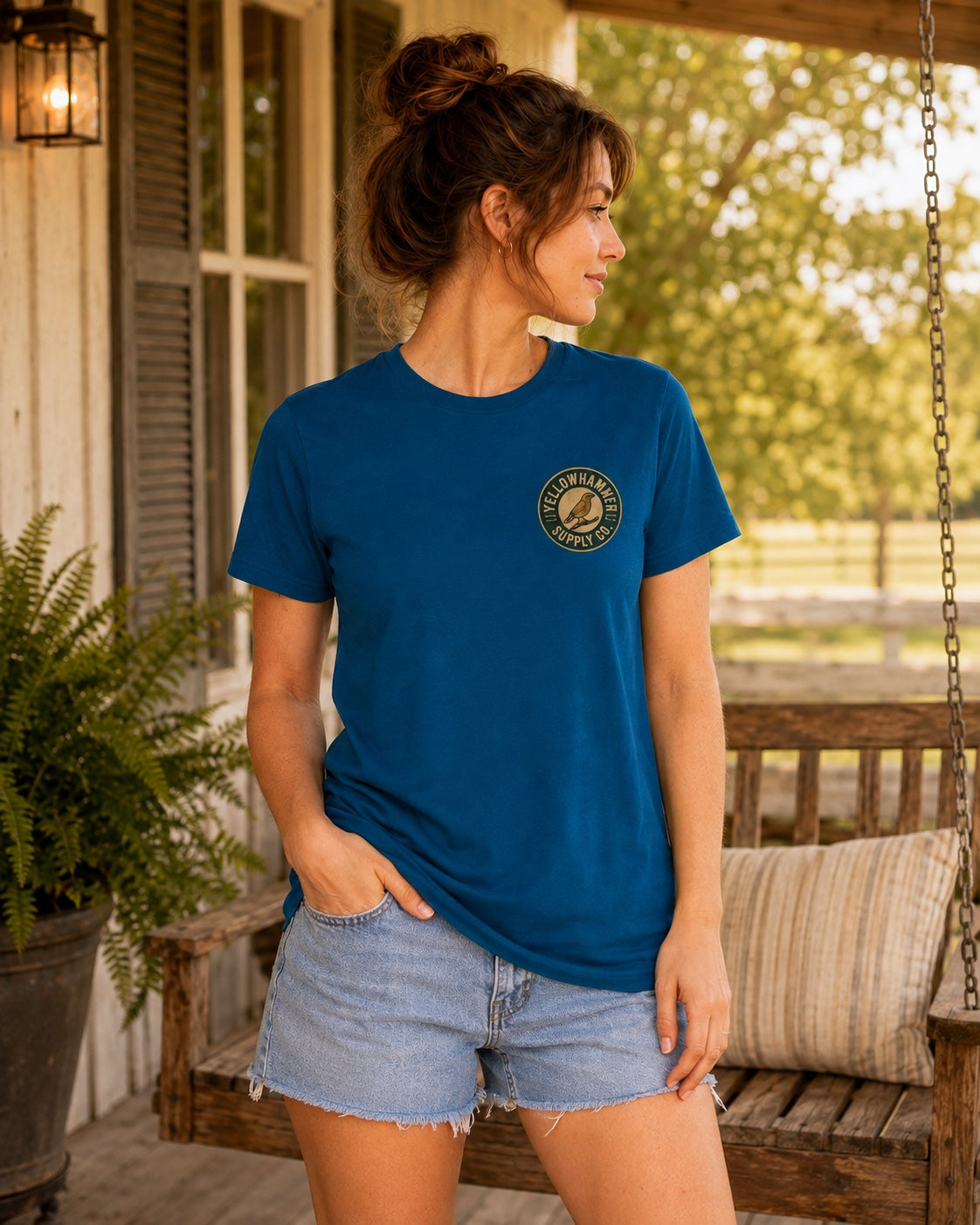 Front view of Yellowhammer Supply Co. Deep Teal T-shirt with left chest Yellowhammer logo on female model